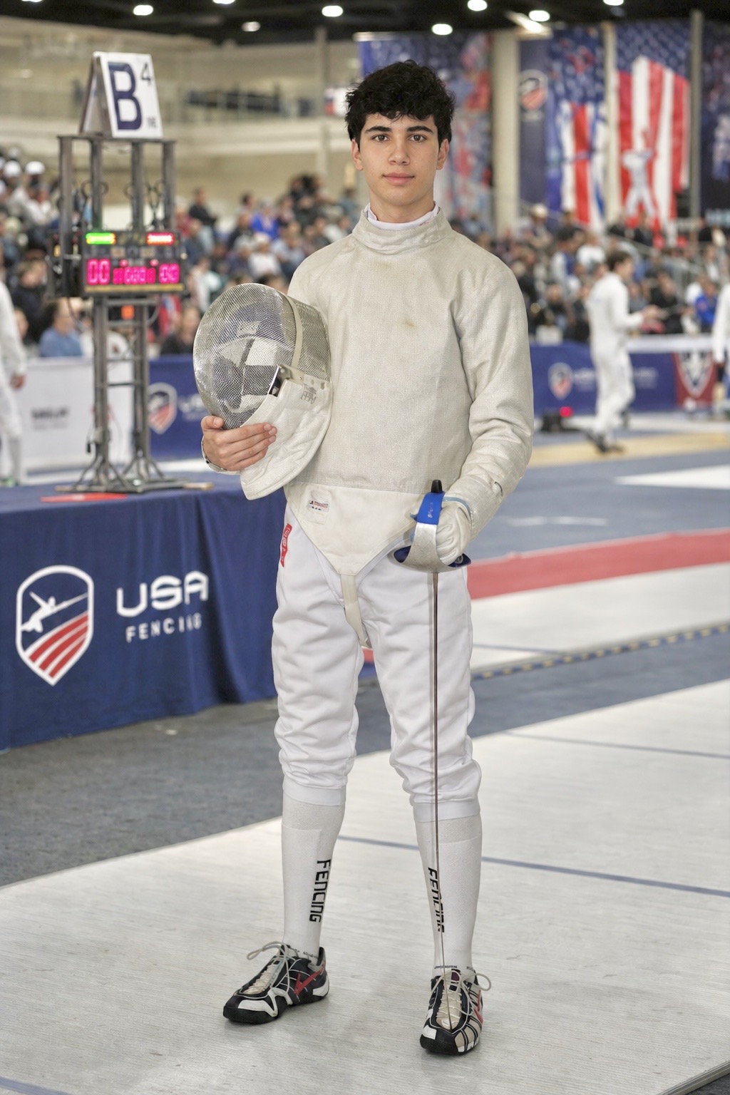Benjamin Gurewich standing on a fencing piste in full competition uniform