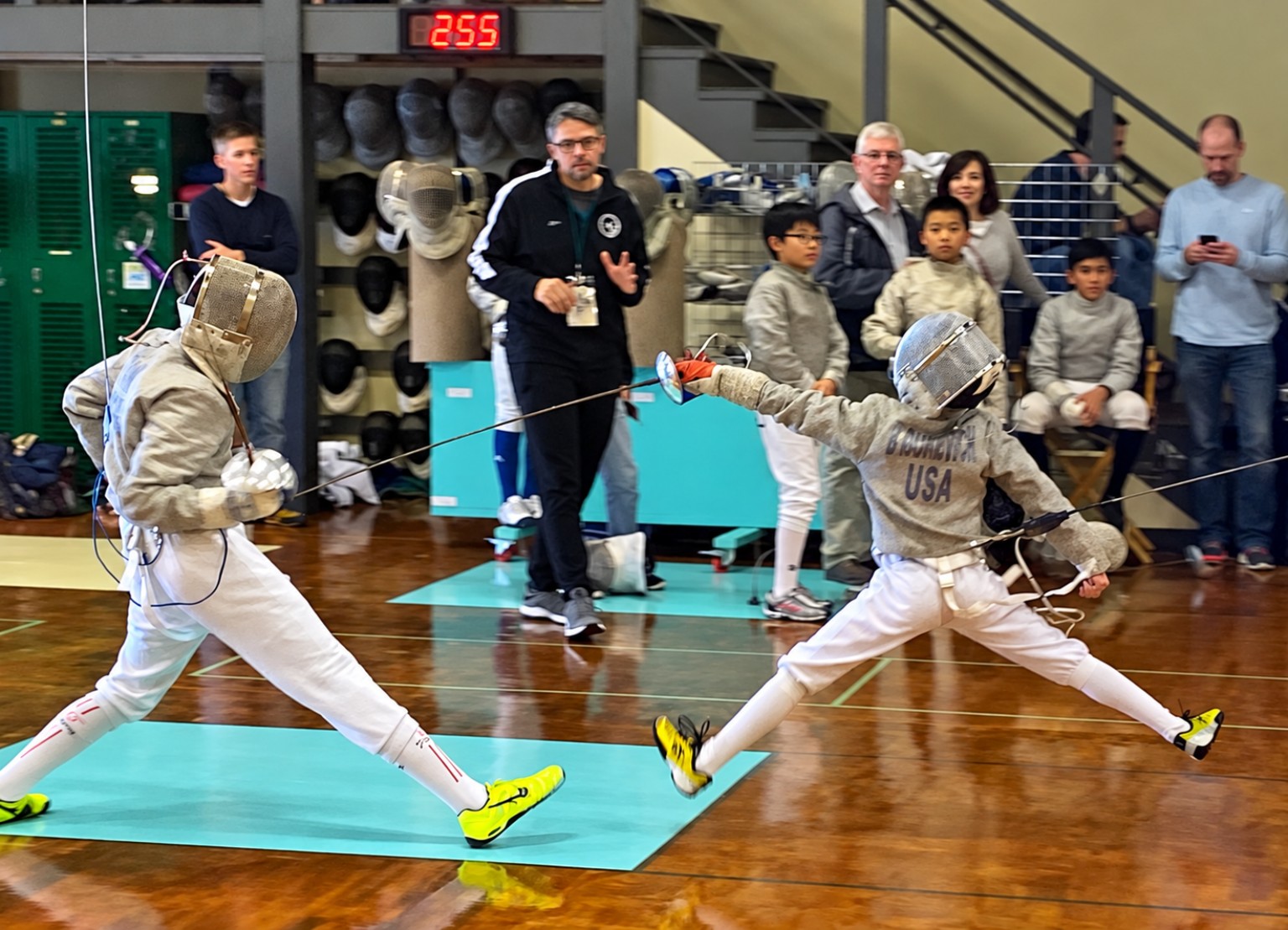 A young Benjamin Gurewich launching an attack against a taller sabre opponent