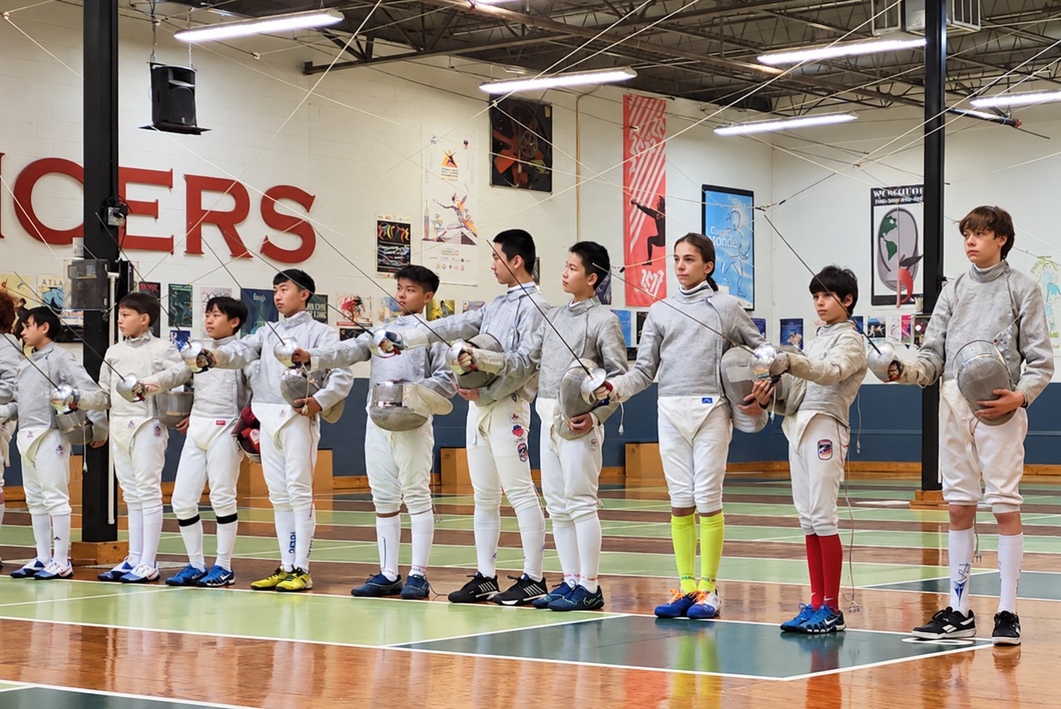 Benjamin Gurewich standing in a lineup of young sabre fencers