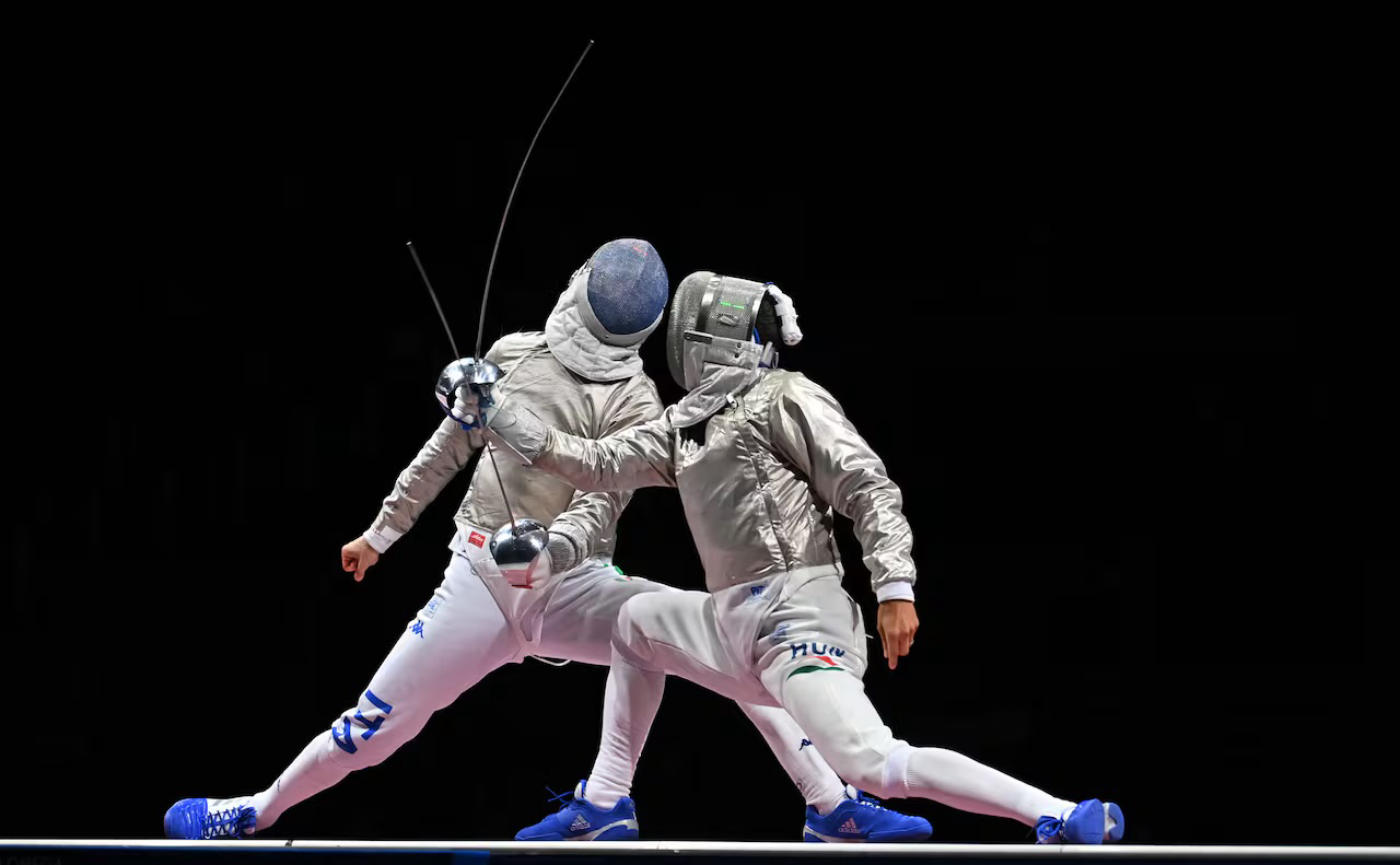 Two fencers in a competitive exchange
