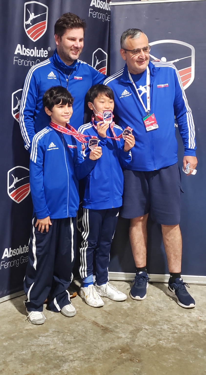Tim Morehouse with Benjamin Gurewich and young medalists at a fencing competition
