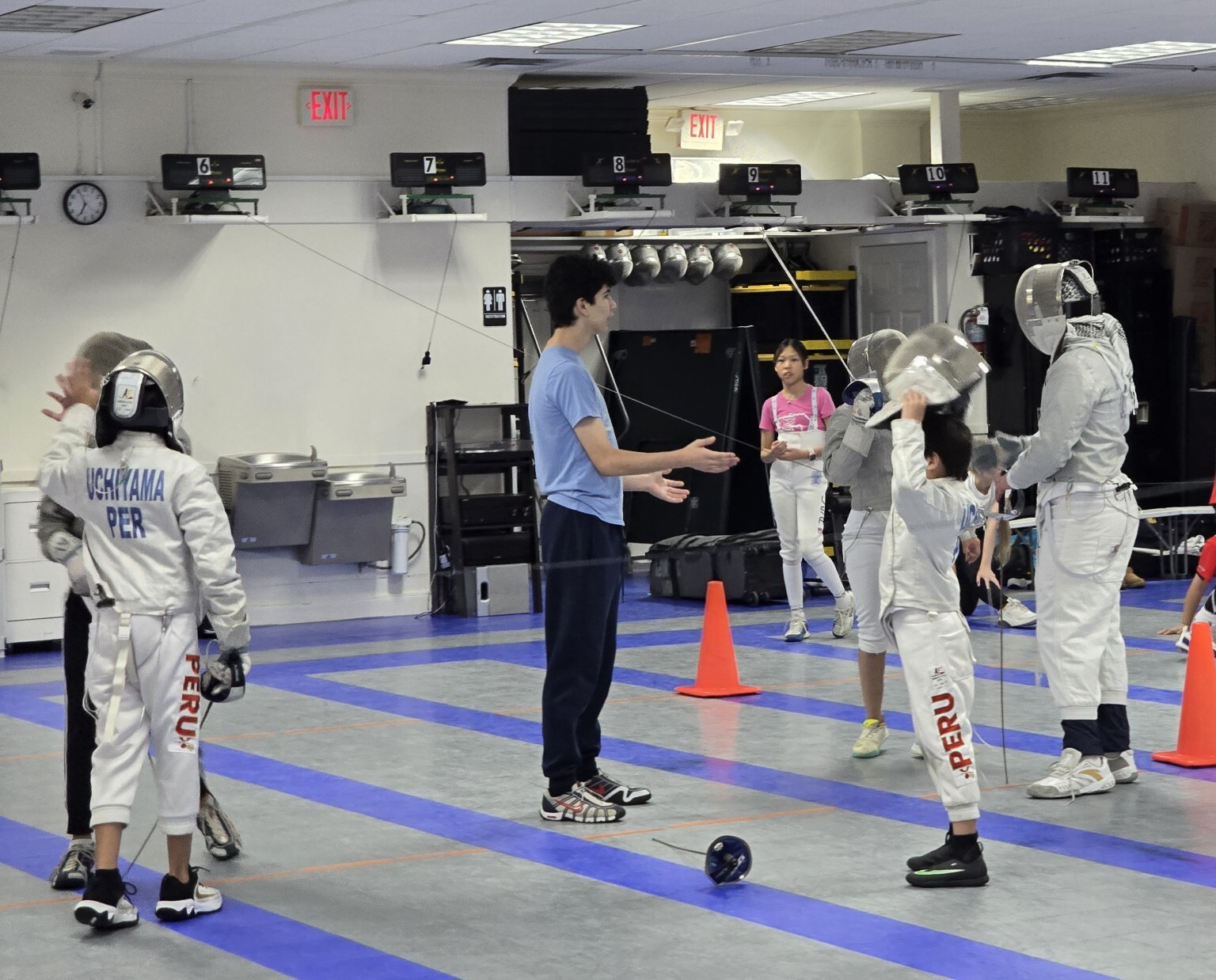 Benjamin Gurewich coaching young sabre fencers during group practice